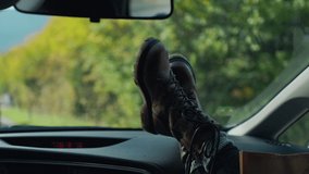 young woman enjoys traveling car by sticking out her legs. Cinematic inspirational video of young woman travelling by car or camper van, opens window to breathe fresh air of countryside, moves hand in