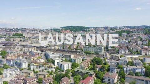 Inscription on video. Lausanne, Switzerland. Flight over the central part of the city. La Cite is a district historical centre. Glitch effect text, Aerial View