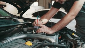 Professional car mechanic use electrician voltage multimeter, working in auto repair service. Regular preventative car maintenance. Auto service, maintenance concept. Troubleshooting a car engine - Powered by Shutterstock - Get 15% off with code: PIKWIZARD15