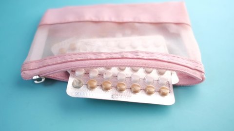 birth control pills on wooden background, close up 