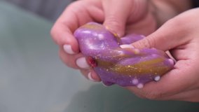 Girl stretching color slime to the sides. Trendy liquid toy sticks to hands and fingers. Popular kids toy