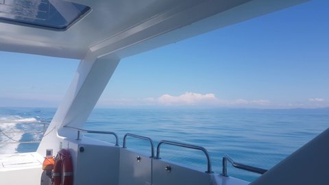 4k video, view from the deck of a luxury yacht to the sea and the horizon line on the background of the sea, bright sunlight, boat movement on the waves.