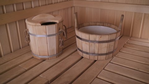 Spa concept of traditional old Russian sauna. Interior details Finnish sauna steam bath with traditional sauna accessories. Wooden basin in the interior of the sauna.