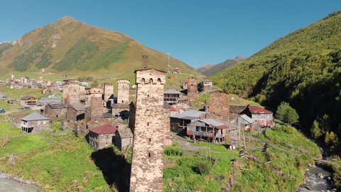 Beautiful landscape of the Ushguli village with Svan towers in Svaneti region in Georgia. Medieval stone tower houses with Caucasus Mountains at background. Slow zoom out