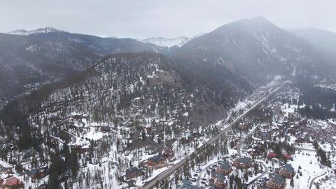 Aerial View of Mountain Winter Landscape Above Keystone Village, Colorado USA, Dark Clouds and Snowfall, Drone Shot