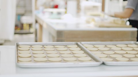 Selective focus and blurred background of beautiful bright and white decorative bakery kitchen with people or chef is working to prepare dough for making fresh dessert and bread for lunch or dinner.