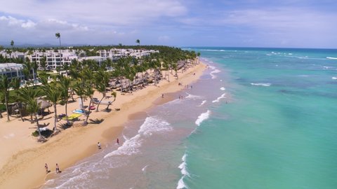 Finest Punta Cana, Dominican Republic - March 20, 2022. Palm beach on the sea sandy coast. Turquoise sea waves on golden sand.Rest and relaxation on a sunny summer day on a beautiful beach. 