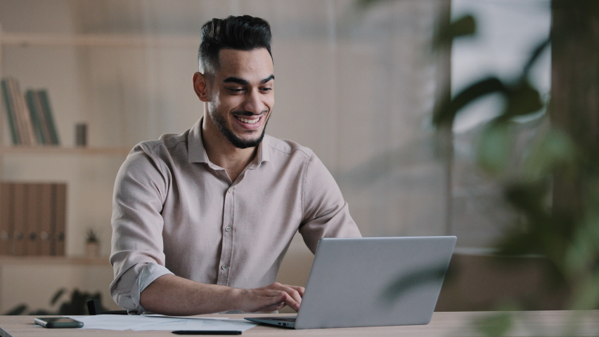 Smiling happy arab man worker businessman finished task computer work relax sit at workplace desk put hands behind head feel satisfied with work well done stress relief taking break after success deal Royalty-Free Stock Footage #1089366217