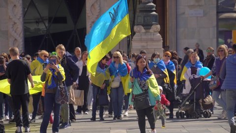 Ukrainian women and refugee men protest in Milan's Piazza Duomo against the war and against Russian leader Putin. death and war in Ukraine. people with placards, flags Europe, Italy Milan, april 2022