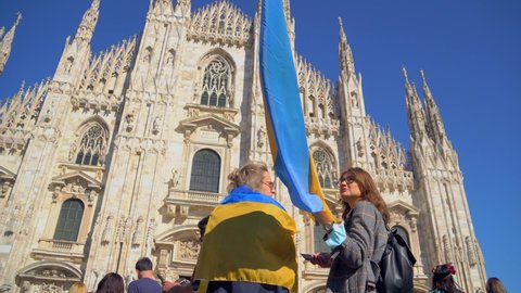 Ukrainian women and refugee men protest in Milan's Piazza Duomo against the war and against Russian leader Putin. death and war in Ukraine. people with placards, flags Europe, Italy Milan, april 2022