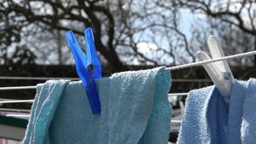 Clothes hung out to dry on a washing line and fastened by the clothes pegs