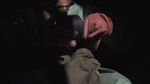 Person wearing protective suit and gloves change filter of gas mask close up view
