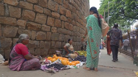 Bengaluru, Karnataka, India, April 2020 - An old woman selling papaya and Java Plum - Roadside, fresh fruits. Shot of the local fruit sellers - Street vendor, customers.