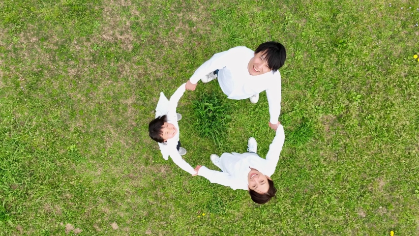 Little girl and parents making circle on the field. Family. Environment. Ecology. Sustainable development goals. SDGs. Royalty-Free Stock Footage #1089372939