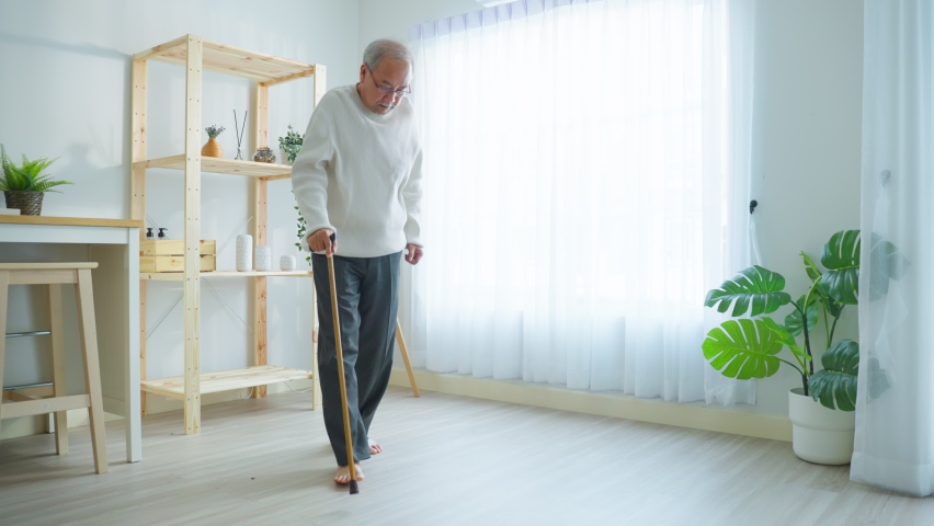 Asian senior older man having chest pain feel suffer from heart attack. Attractive older mature patient has difficulty breath clutching chest from acute pain while walking with walker in living room. | Shutterstock HD Video #1089375623