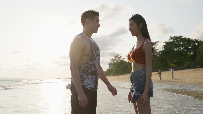 Asian young man and woman having fun, playing on the beach together. Attractive new marriage people feel happy while walking and running at seaside enjoy holiday honeymoon trip in tropical sea island. Royalty-Free Stock Footage #1089375729