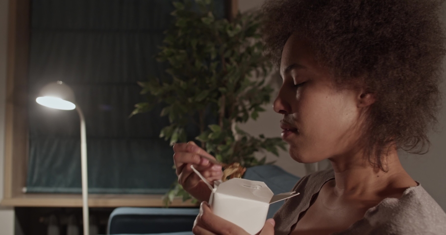 African American woman eating noodles for dinner