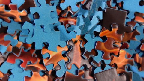 Background of Colored Puzzle Pieces that Rotating Clockwise - Top View, Close-Up. Texture of Incomplete Red and Blue Jigsaw Puzzle - Right Rotation