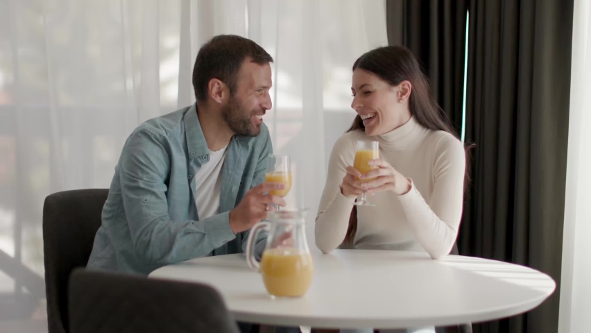 Young couple in the living room drinking orange juice