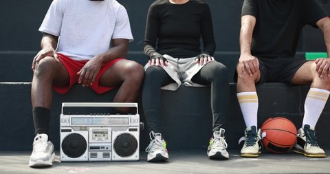 Group of young african people listening music from vintage boombox stereo outdoor after basketball match