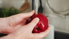 Female hands washing apple under water in sink. Washing the red apples in woman hands. - Powered by Shutterstock - Get 15% off with code: PIKWIZARD15