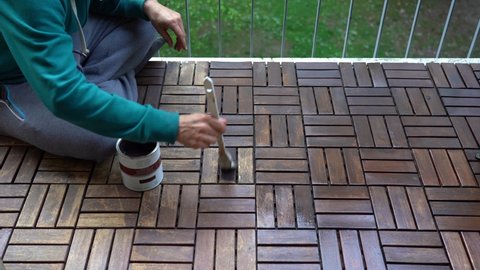 apply a protective varnish with a brush on the balcony wooden parquet as spring arrives - DIY projects bricolage  at home