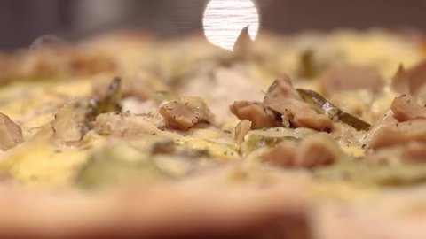 blurred background with hot round pizza on the table, dolly camera movement