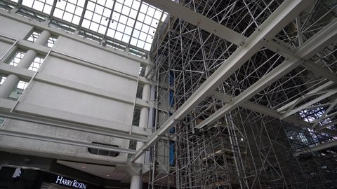 Toronto , Ontario , Canada - 04 07 2022: Bare scaffolding envelopes white structural steel girders during renovation, CF Toronto Eaton Centre shopping mall in Ontario, Canada