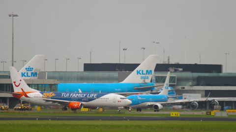 AMSTERDAM, THE NETHERLANDS - JULY 27, 2017: Boeing 737 with livery TUI FAMILY LIFE taxis from the terminal to the airfield at Schiphol Airport. Busy aviation traffic at Amsterdam Airport