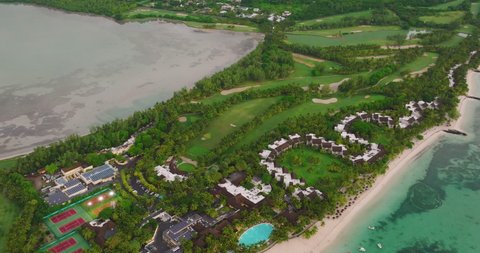 Golf hotel on the rocky coast Indian ocean. Golf course and villas on the beach. Mauritius