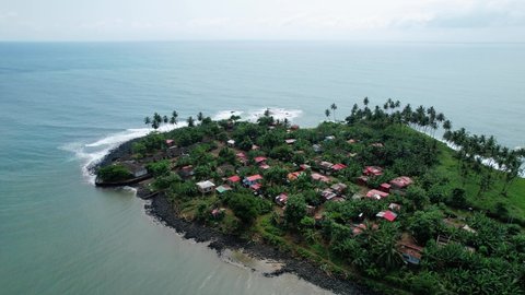 Aerial view around a town at the Baia da Praia do Rei agua Ize, in Sao Tome, Africa - orbit, drone shot