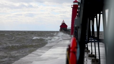 Waves crashing on Grand Haven, Michigan pier and lighthouse on Lake Michigan.