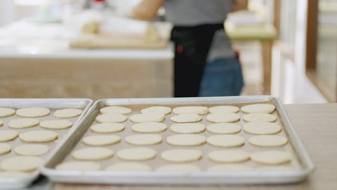 Selective focus and blurred background of beautiful bright and white decorative bakery kitchen with people or chef is working to prepare dough for making fresh dessert and bread for lunch or dinner.