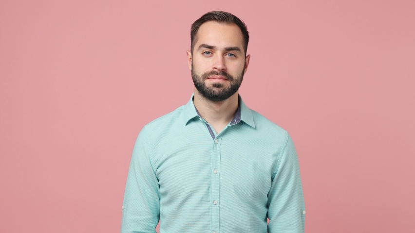 Happy bright fun moody disappointed young brunet man 20s years old wears blue shirt looking camera smiling getting sad isolated on plain plain pink background studio. People emotions lifestyle concept Royalty-Free Stock Footage #1089417527