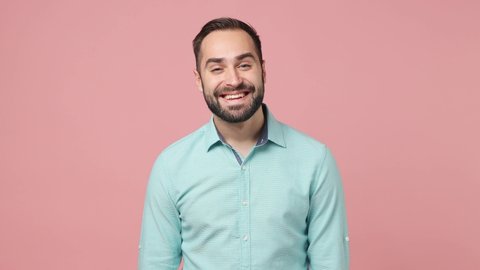 Happy bright fun moody disappointed young brunet man 20s years old wears blue shirt looking camera smiling getting sad isolated on plain plain pink background studio. People emotions lifestyle concept