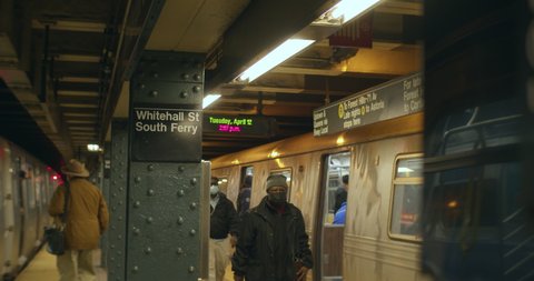 New York, New York United States - April 12,  2022: Passangers exit and enter subway trains at the Whitehall Street, South Ferry Subway station. 