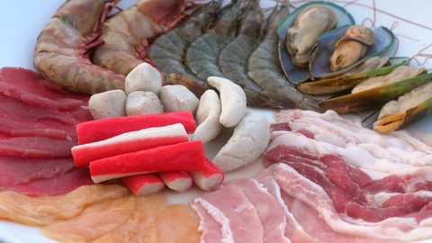 Assortment of fresh seafood, meat for cooking in grill or hot pot. Traditional asian food - raw river prawn or shrimps prepared for Japanese shabu shabu or sukiyaki. Healthy steamed food