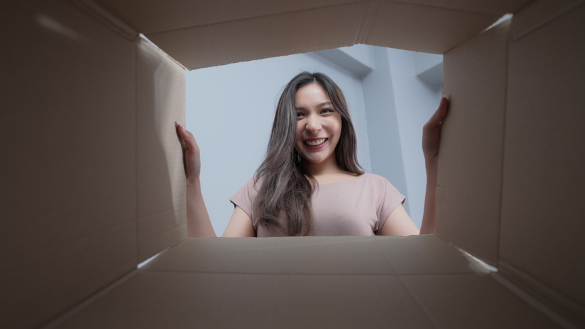 Holiday concept of 4k Resolution. The young woman opened the box and looked at the product with delight.
