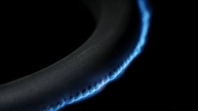 Burning gas burner in the oven close-up on a black background. 4k macro raw video.
