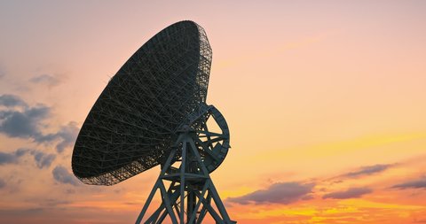 Astronomical radio telescope and beautiful sky clouds at sunset. 4K time lapse footage.