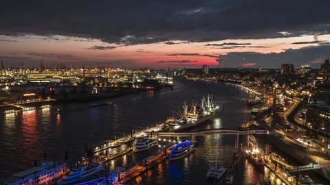 Establishing Aerial View Shot of Hamburg De, Mecklenburg-Western Pomerania, Germany at night evening, view from river, super clear image, push in, magical sunset in port