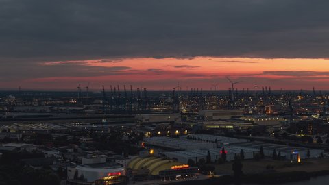 Establishing Aerial View Shot of Hamburg De, Mecklenburg-Western Pomerania, Germany at night evening, view from river, super clear image, wonderful sunset in port, wind turbines