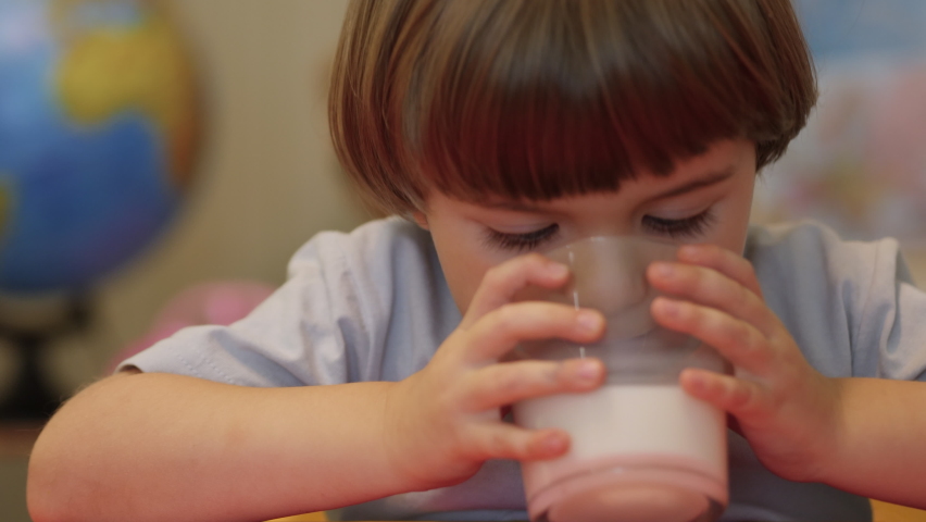 Healthy Eating Child Eating Breakfast Kid Dream Concept. Son Boy in Home Drinks Milk From a Glass cup. Positive Kid Smiling Having Breakfast. Little Boy Child Drinking Milk.  Royalty-Free Stock Footage #1089435655