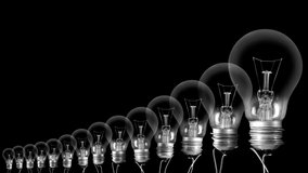 Shining light bulb with New Year 2023 and group of dark light bulbs in a row going from 2010 to 2022 isolated on black background. High quality 4k video.
