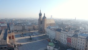 Krakow Poland Market Main Square. Old town. Aerial video footage. camera is moving towards to Cloth Hall and  Adam Mickiewicz Monument over the square . Beautiful morning fog