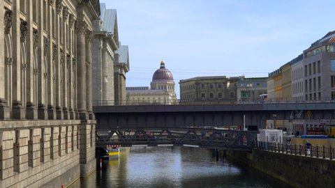 Berlin, Germany - 15.04.2022: S-Bahn train passing by on the bridge of Museum Island. The building of Humboldt Forum on the background