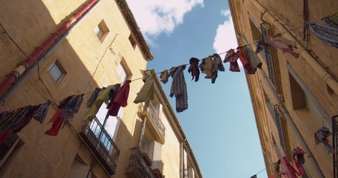 Drying Clothes Hanging Out To Dry Across The Typical Street In Montpellier, France. Low Angle Shot