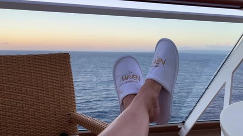 Puerto Plata DR-January 10, 2022: A person sitting with Haven slippers on overlooking the Dominican Republic coast line on the Norwegian Escape cruise ship.