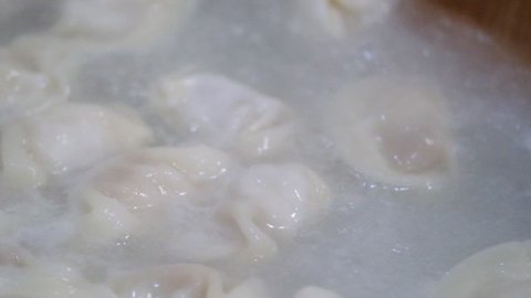 super slow motion. Close up cooking dumpling in boiling water. Cooking traditional Chinese food during Spring Festival