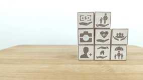 Cube, Insurance and stages of life concept. Hand puts wooden cube with assurance icon standing on finance, education, real estate and health, property, child, family and pension planing icon videos